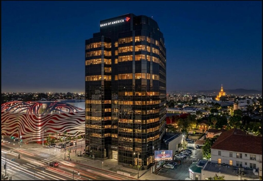 Bank of America Tower illuminated at dusk with light trails on Wilshire below
